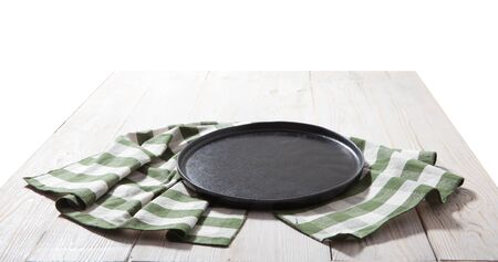 Black plate or tray, or pizza board, with tablecloth on wooden table. Top view mockupの写真素材