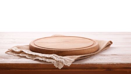 Napkin and board for pizza on wooden desk. Canvas, dish towels on white wooden table background top view mock up. Selective focus.の写真素材