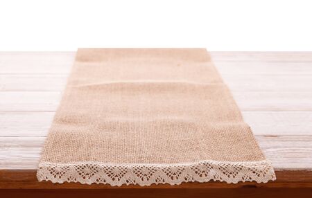 Canvas napkin with lace, tablecloth on wooden table on white background. Can used for display or montage your products. Selective fokus.の写真素材