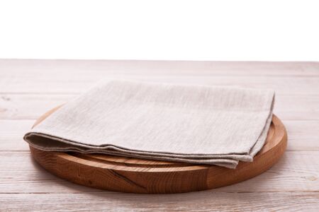 Napkin and board for pizza on wooden desk. Canvas, dish towels on white wooden table background top view mock up. Selective focus.の写真素材