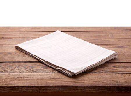 Wooden deck table with white napkin isolated on white background. Kitchen background, product montage display. Mock up.の写真素材