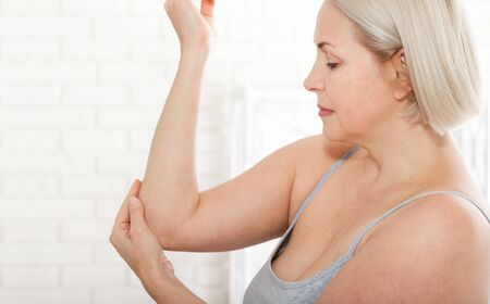 Woman with pain in arm, elbow. Pain in the human body, health care concept.の写真素材
