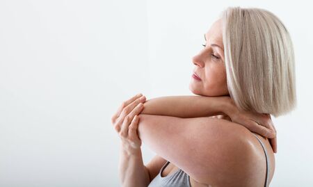 Woman with pain in arm, elbow. Pain in the human body, health care concept.の写真素材