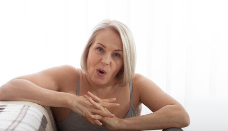 Angry stressed senior middle aged woman annoyed with problems, mad worad mature lady frustrated about bad news at homeの写真素材