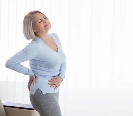 Woman in pain holding her stomach on the right sideの写真素材