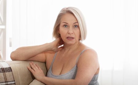 Angry stressed senior middle aged woman annoyed with problems, mad worad mature lady frustrated about bad news at homeの写真素材