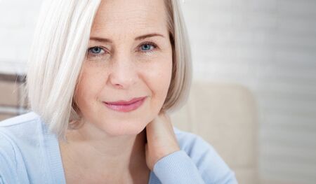 Woman with pain in her neck, medical shot at home. Concept photo with indicating location of the pain.の写真素材