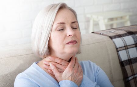 Sore throat woman at home.の写真素材