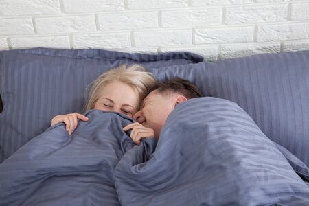 Middle aged cute couple sleeping together in bed. Selective focus.の写真素材