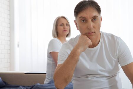 Unhappy middle aged couple in bedroom at homeの写真素材