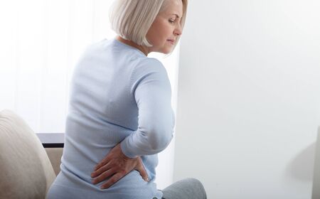 Woman in pain holding her stomach on the right side. Concept photo with indicating location of the pain. Health care conceptの写真素材