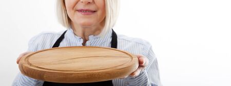 attractive woman waitress gives empty pizza board for your advertising products isolated on white background. Mock up for useの写真素材