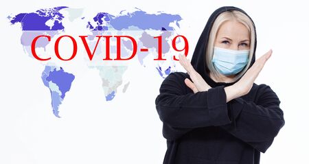 Woman wearing face mask. Concept coronavirus, respiratory virus. Sign with hands stop. Text Covid-19の写真素材