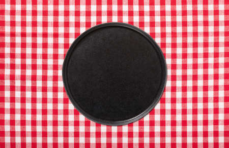 Empty pizza board and tablecloth on wooden deck table with napkinの写真素材
