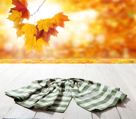 Table cloth on wooden deck table with napkin. Autumn background.の写真素材