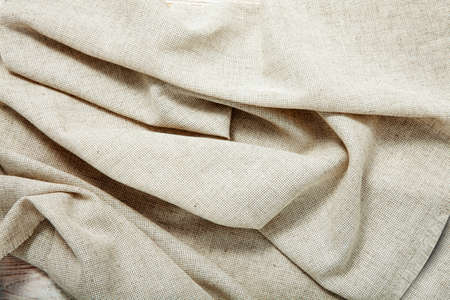 White napkin tablecloth . Wrinkled fabric background top view.の写真素材