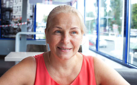 Happy beautiful middle aged woman in cafe. Face closeupの写真素材