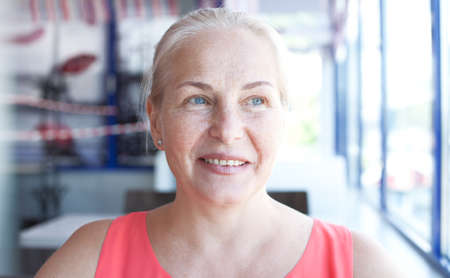 Happy beautiful middle aged woman in cafe. Face closeupの写真素材