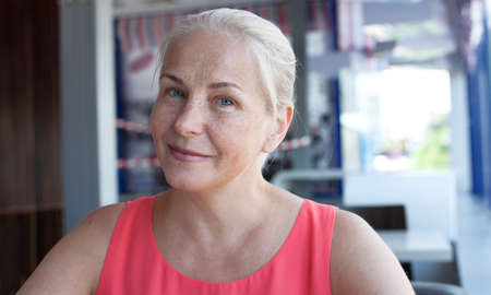 Happy beautiful middle aged woman in cafe. Face closeupの写真素材