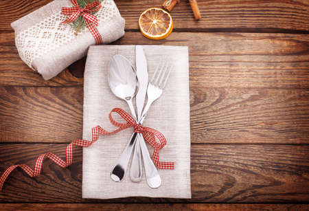 Gift box is festively decorated with Christmas branch and on wooden deskの写真素材