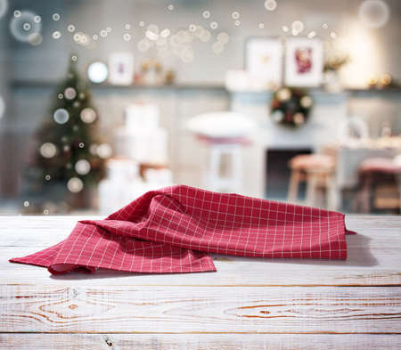 Red napkin on wooden table and Christmas background.の写真素材