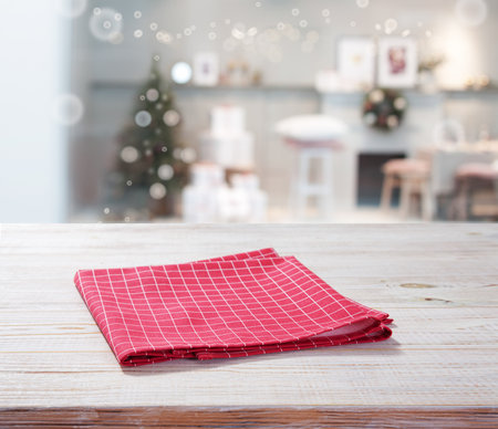 Red napkin on wooden table and Christmas background.の写真素材
