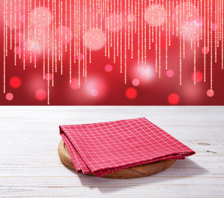 Red napkin on wooden table and Christmas background mockup.の写真素材