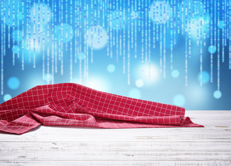 Red napkin on wooden table and Christmas background.の写真素材