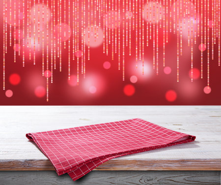 Red napkin on wooden table and Christmas background.の写真素材