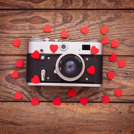 Retro Camera with red hearts on wooden background.の写真素材