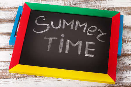 Blackboard with text its summer time on wooden deskの写真素材
