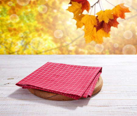 Empty pizza board and red napkin on white wooden