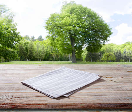napkin, tablecloth on wooden deck front view mockup. summer landscape backgroundの写真素材