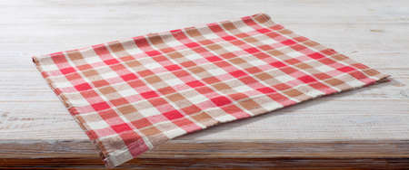 Folded towel, napkin linen tablecloth on wooden desk perspective. Mock up. selective focus.の写真素材