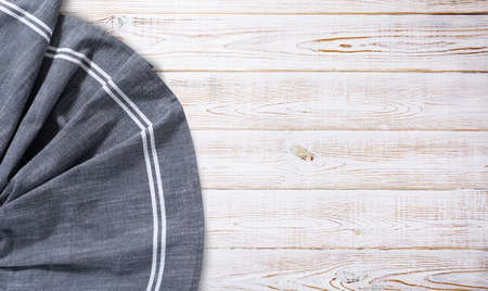 Blue tablecloth, napkin, rough fabric texture with creased folds on wooden desk. top view.の写真素材