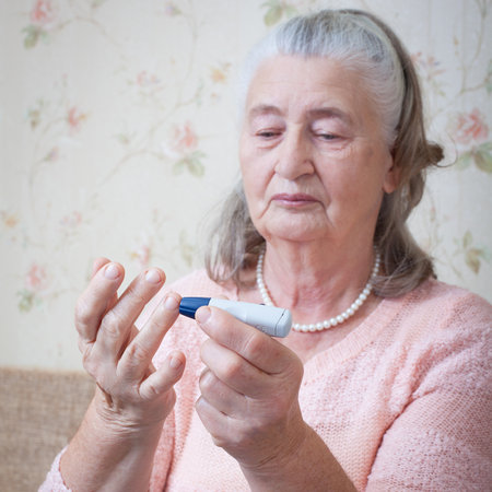 Senior woman checking blood sugar level using glucometer. Closeup hand of old person with diabetes. Diabetes treatment for elderly people.の写真素材