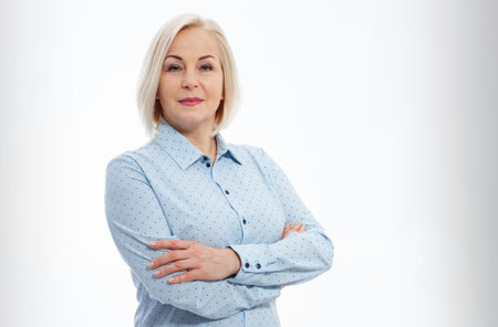 Attractive busines woman with folded arms isolated on gray backgroundの写真素材
