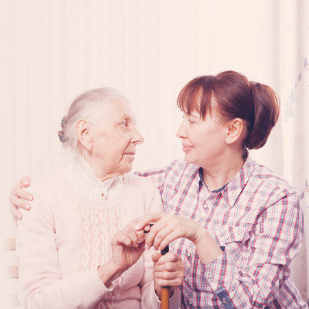Care of senior woman at home sitting on the couchの写真素材