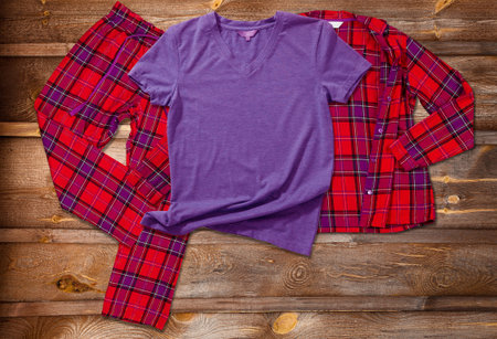 Blank t-shirts for the whole family on the background of bright pajamas on a wooden background.の写真素材