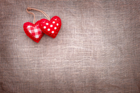 Love hearts on textile texture background. Valentines day card concept. Two handmade hearts for Valentines Day Background.の写真素材