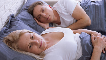 Unhappy middle aged couple in bedroom at homeの写真素材