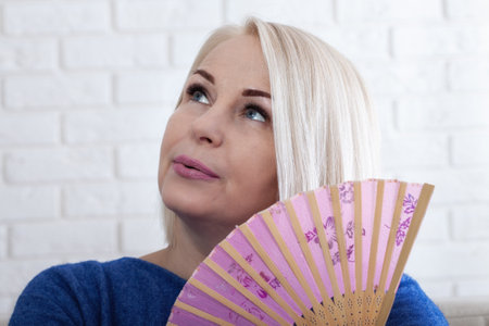 Mature woman experiencing hot flush from menopauseの写真素材