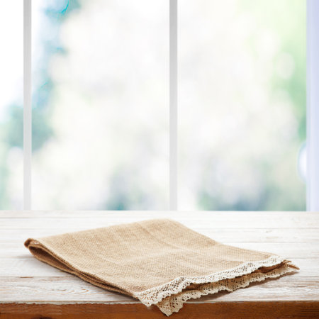Rustic Chic: Wooden Table with a Napkin in Perspective. Canvas napkin with lace, tablecloth on wooden table on a sunny day. Can be used for display or installation of your products. selective focusの写真素材