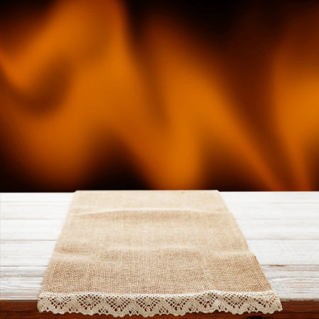 Rustic Chic: Wooden Table with a Napkin in Perspective. Canvas napkin with lace, tablecloth on wooden table and bright background. Can be used for display or installation of your products. selective focusの写真素材