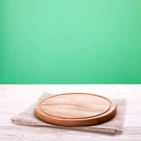 Board for pizza and napkin on wooden table. Canvas, dish towels on white wooden table and green background top view mock up perspective. selective focus.の写真素材