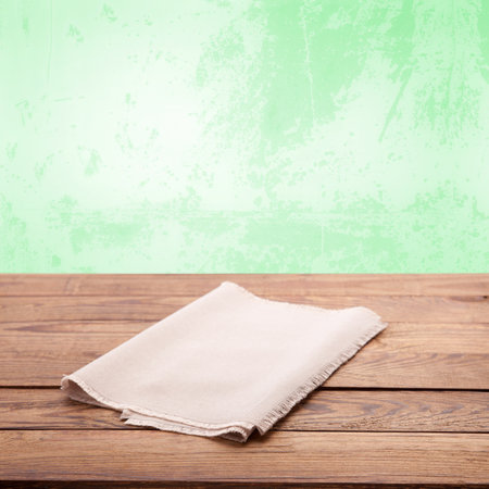 Empty white napkin on wooden table with spring green background. Napkin close up top view mock up. Sophisticated Kitchen Aesthetic rustic chic background.の写真素材