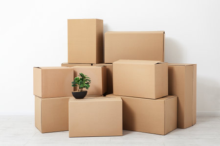 Cardboard boxes pile of brown carton box. Moving in. Stack of cardboard boxes on the flor in the empty room with copy space mock up.の写真素材
