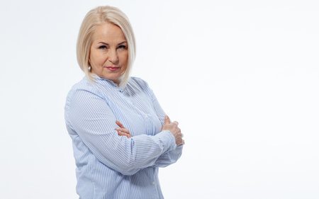 Serious business woman with folded arms on white backgroundの写真素材