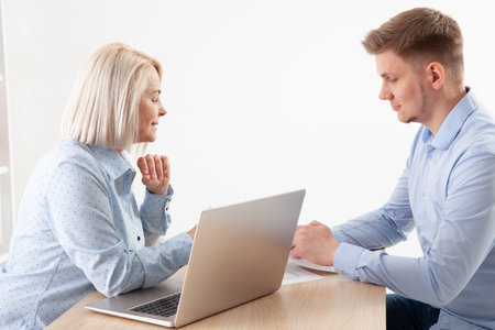 In the companys office, a smiling businesswoman conducts an interview with a job applicant.の写真素材
