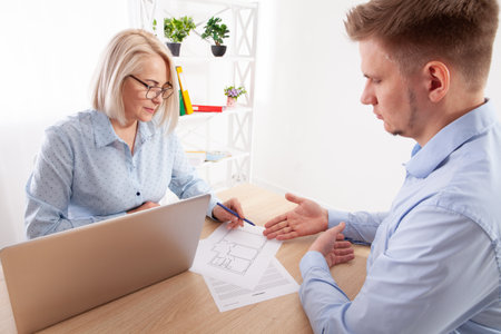 A financial consultant conducts a meeting with a client in their office.の写真素材